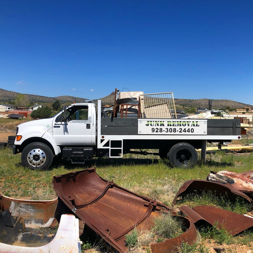 True West flatbed truck loaded with scrap furniture and fencing