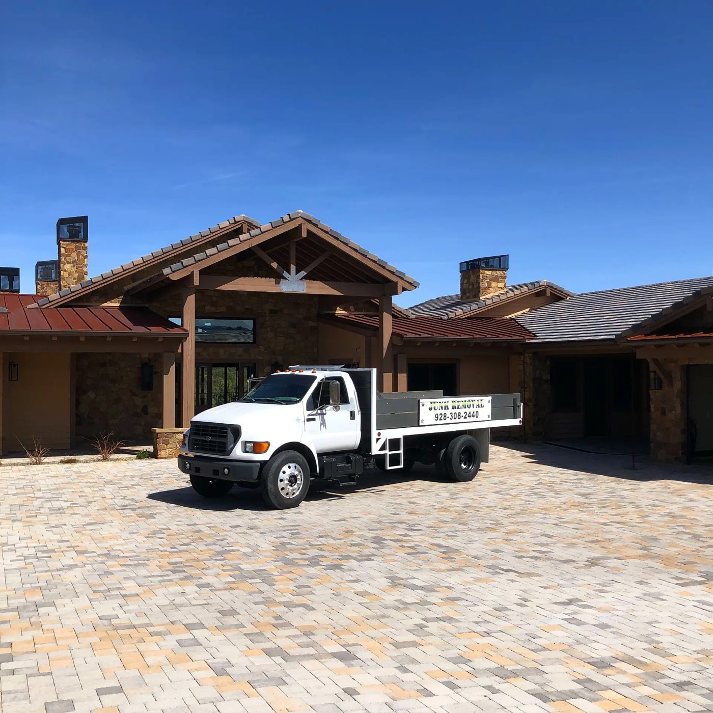 True West Co. junk removal flatbed dump truck parked at an Arizona home